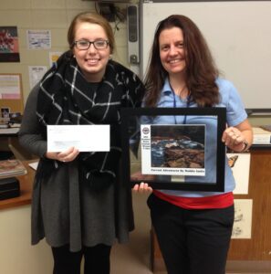 Maddie Leslie (with her winning photograph and check) and Lori Forrester, CCWSA Environmental Affairs Specialist, at Woodstock High School