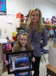 Audrey Hopkins (with her winning photograph) and her mother Brooke Hopkins at Macedonia Elementary School